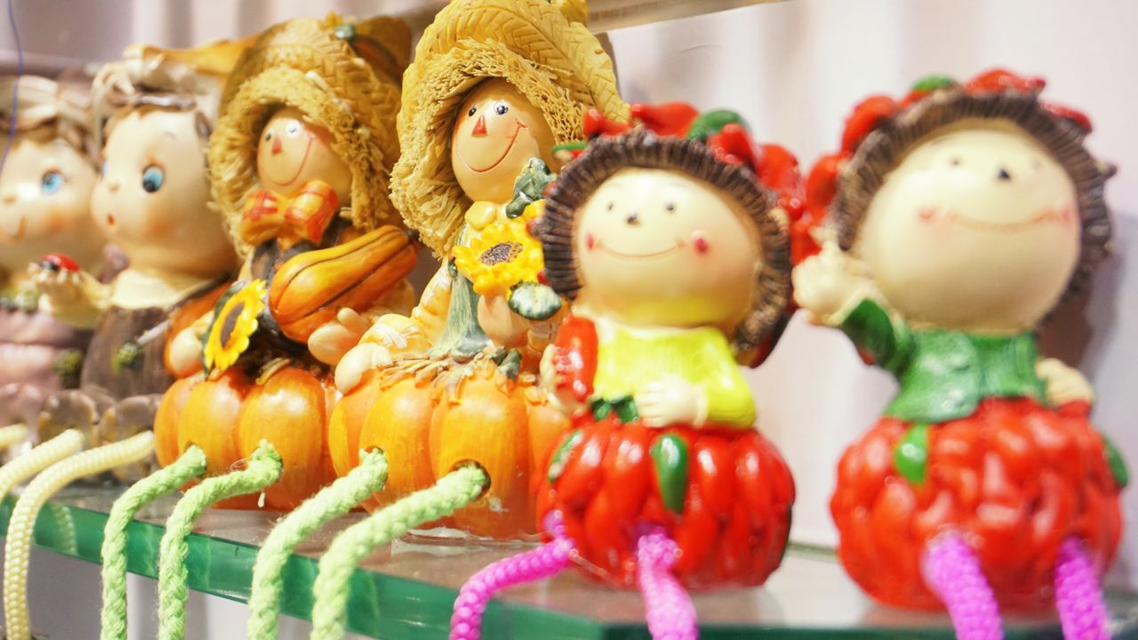 Charming display of autumn-themed decorative dolls with vibrant colors, adding festive joy to interiors.