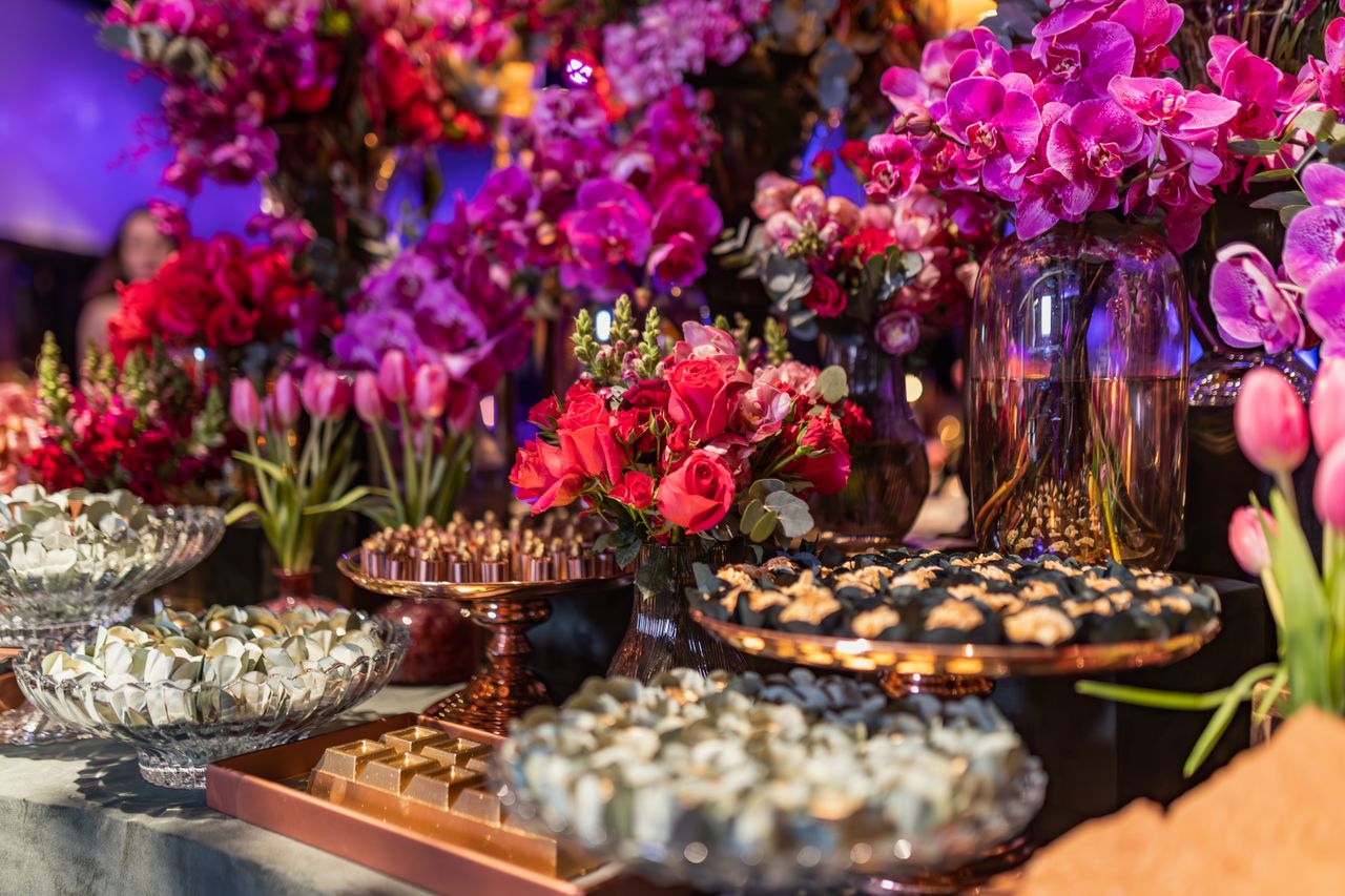 Elegant arrangement of flowers and desserts with a luxurious feel in an indoor setting.