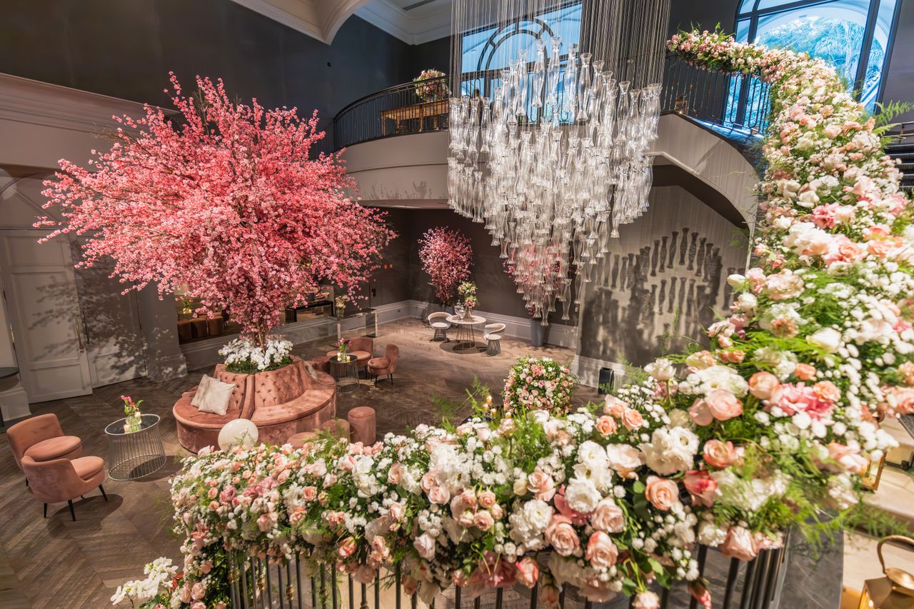 Luxurious wedding venue featuring pink floral arrangements and stunning chandelier.